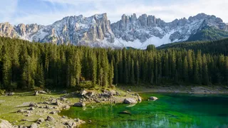 Karersee Camping: In the clear waters of Lake Karersee, fir trees and mountains are reflected