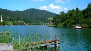 The banks of the Schliersee in Bavaria with a bridge and forests in the background