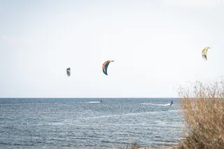 The sea and some windsurfers in the distance.