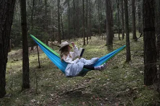 Frau liegt in einer Hängematte im Wald