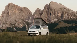 Dolomites Secret Tips: An off camper with a canopy rides a road in the Dolomites