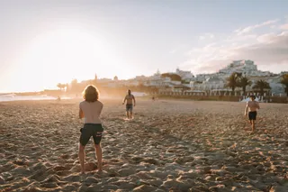 Beach view of a group of people playing volleyball